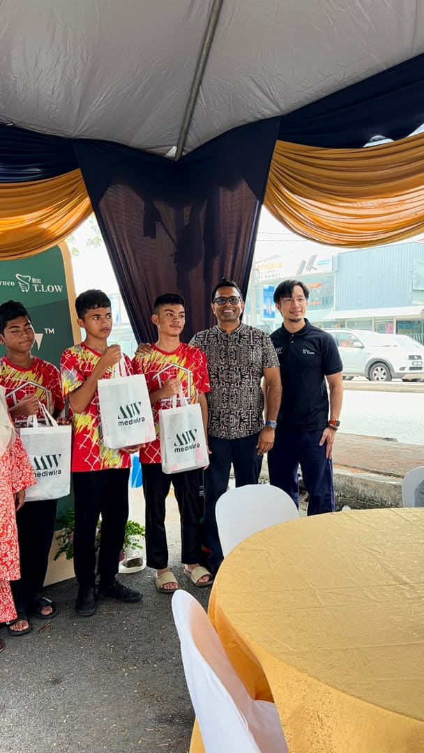 Boys posing with the clinic’s team, holding their Mediwira tote bags at the anniversary backdrop
