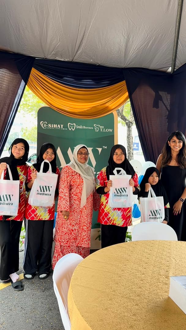 A family group holding their Mediwira tote bags at the backdrop