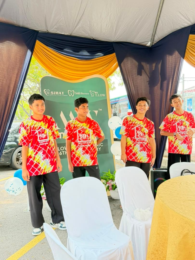 Four boys posing together at the anniversary backdrop